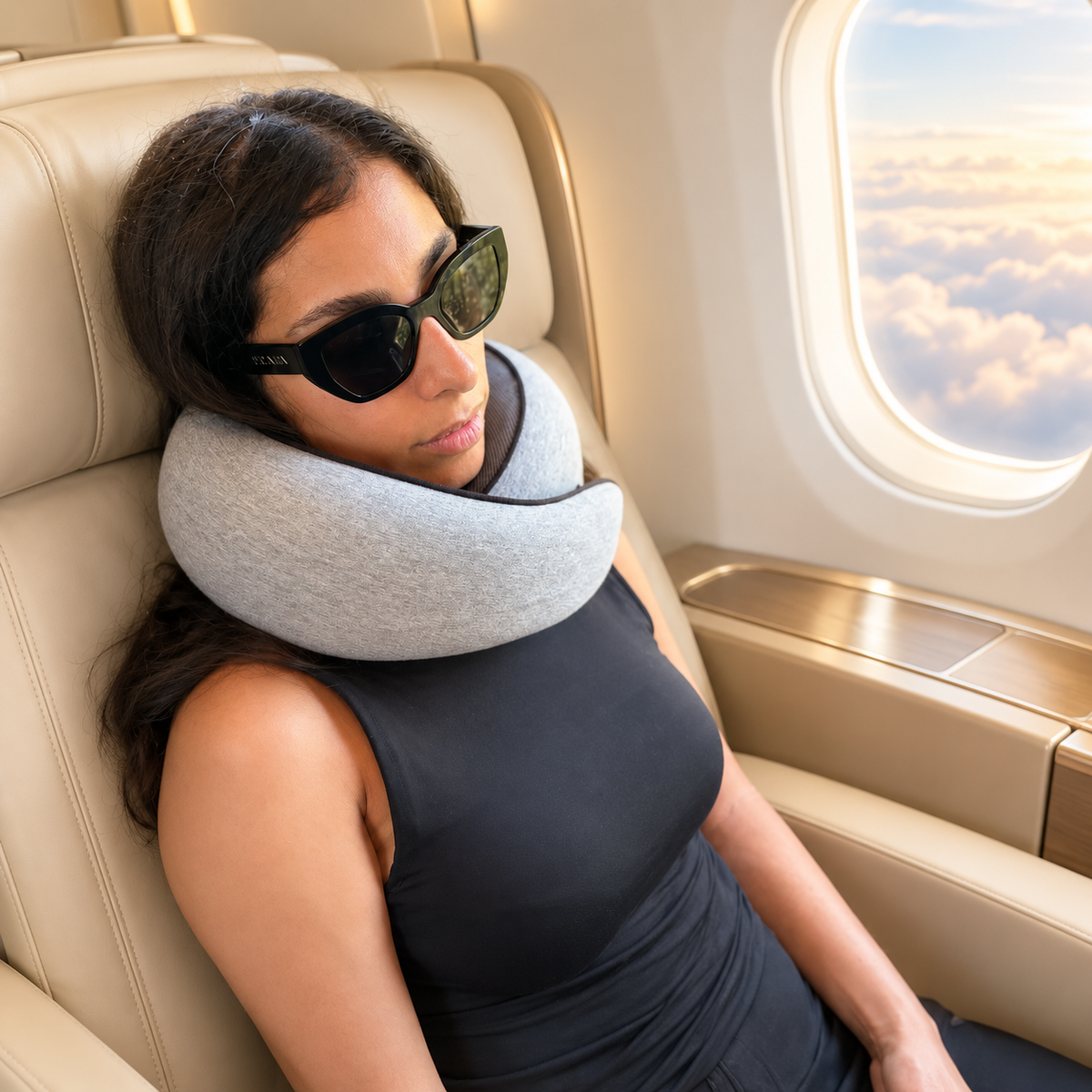 Woman wearing DreamCatcher travel pillow and sunglasses on a plane